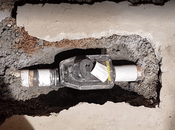 Backwater valve installed on a residential sewer lateral in a Grand Rapids basement to prevent sewer backups during heavy rain.