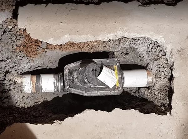 Backwater valve installed on a residential sewer lateral in a Grand Rapids basement to prevent sewer backups during heavy rain.