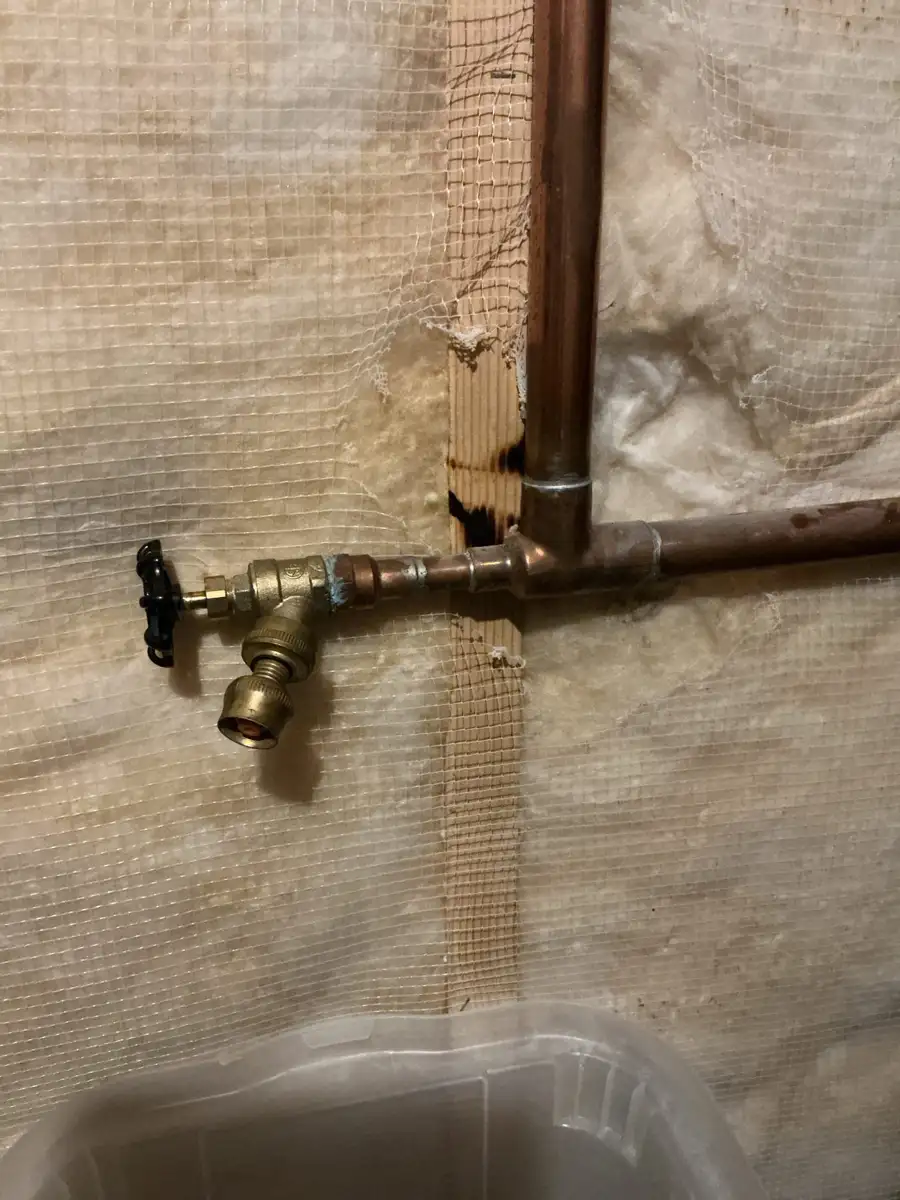 Freeze resistant outdoor faucet installed on a copper line inside an insulated basement wall