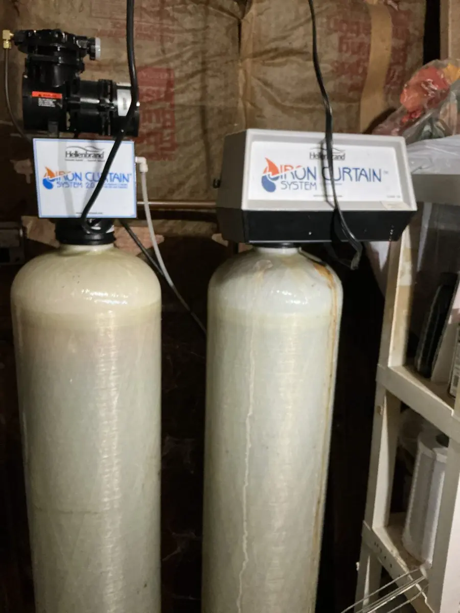 Two iron filter tanks installed ahead of the water softener on a well system