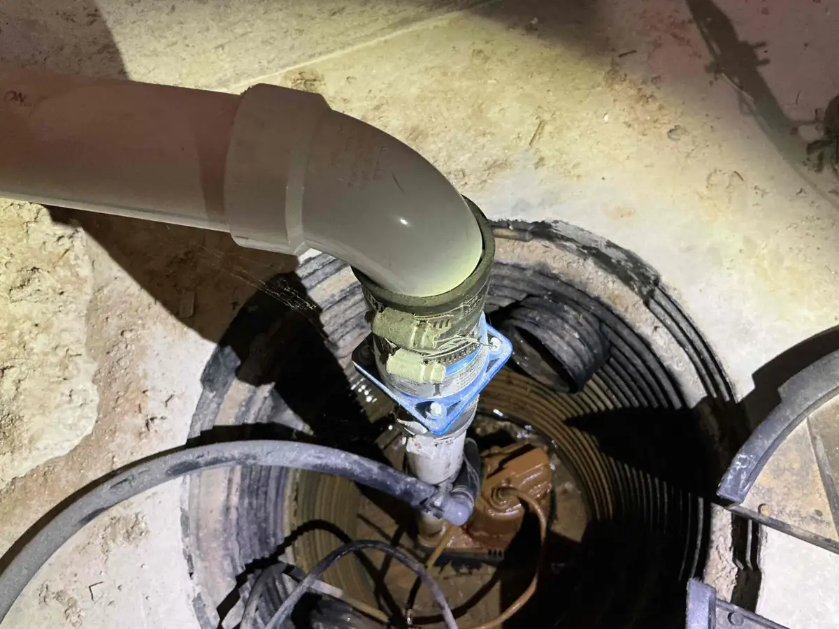 New submersible sump pump installed with a check valve and rubber union on the discharge pipe