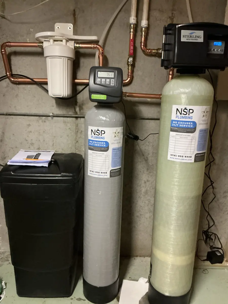 New water softener, brine tank and second treatment tank installed side by side in a basement