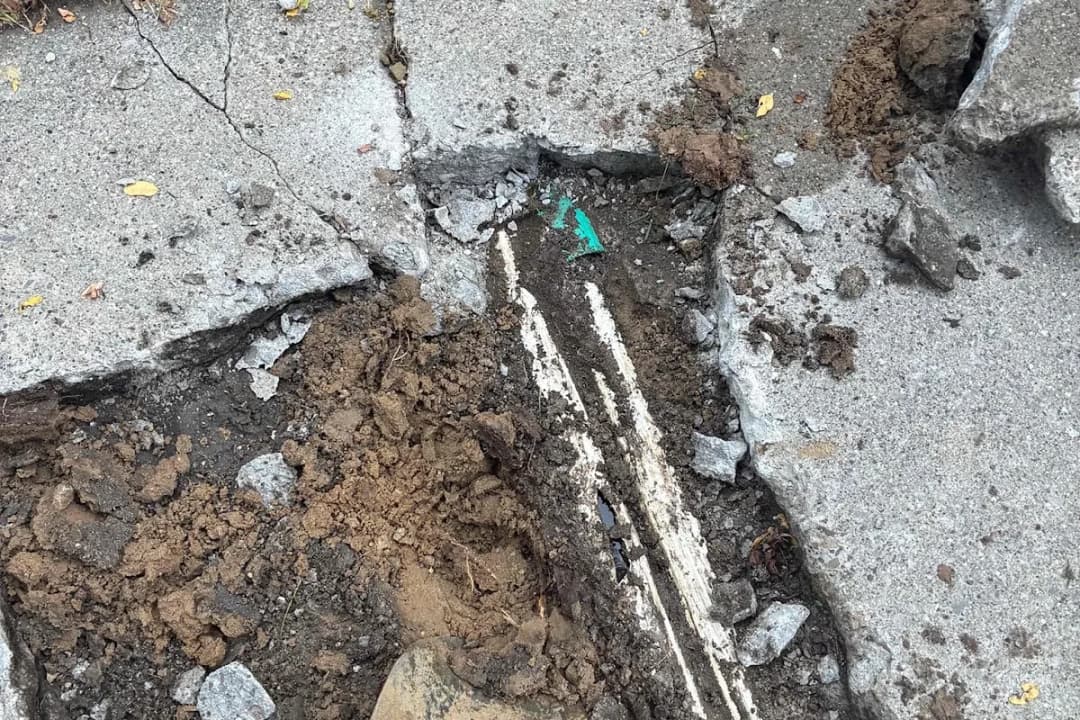 Section of sidewalk cut out and removed to reach a failed sewer line in Grand Rapids