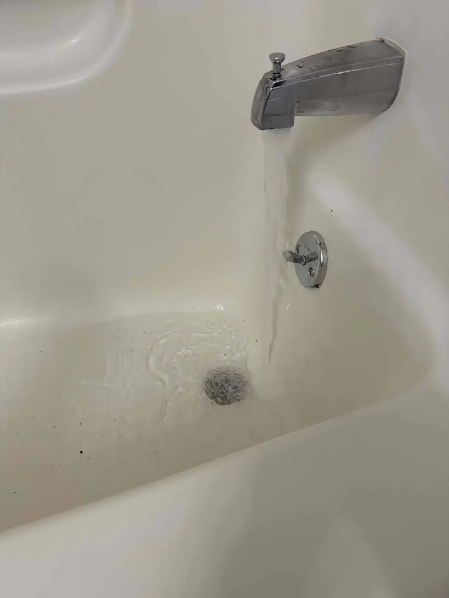 Bathtub draining freely with water running from the faucet after the clog was cleared