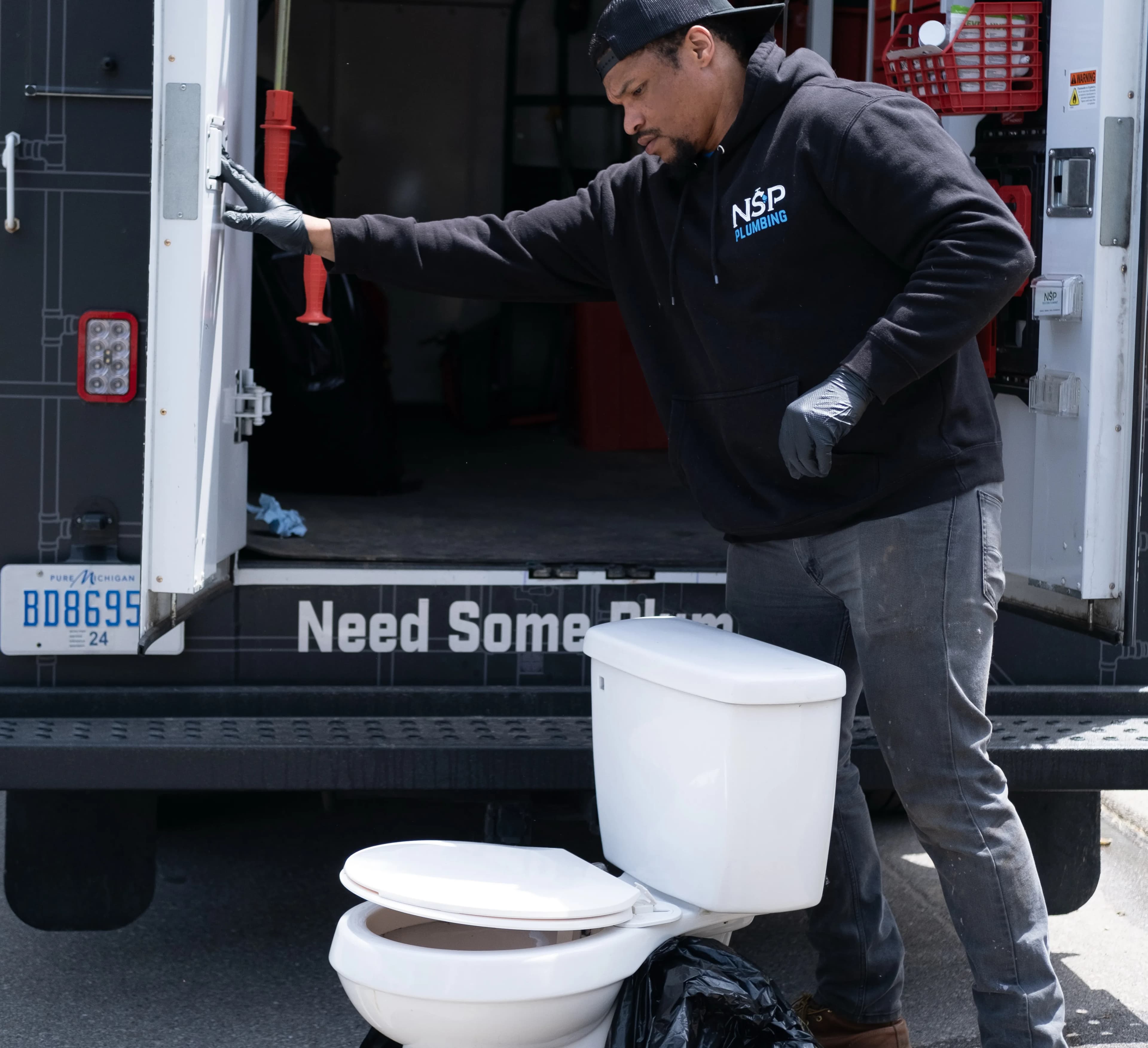 NSP Plumbing licensed plumber installing a toilet in a Grand Rapids, MI bathroom