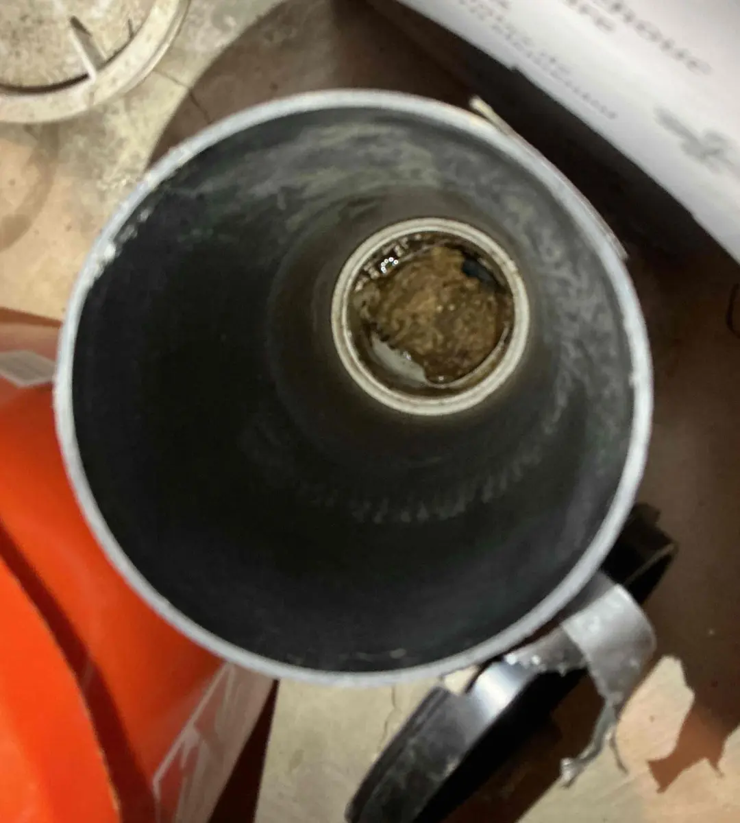 Inside of a kitchen drain pipe narrowed by years of grease and buildup