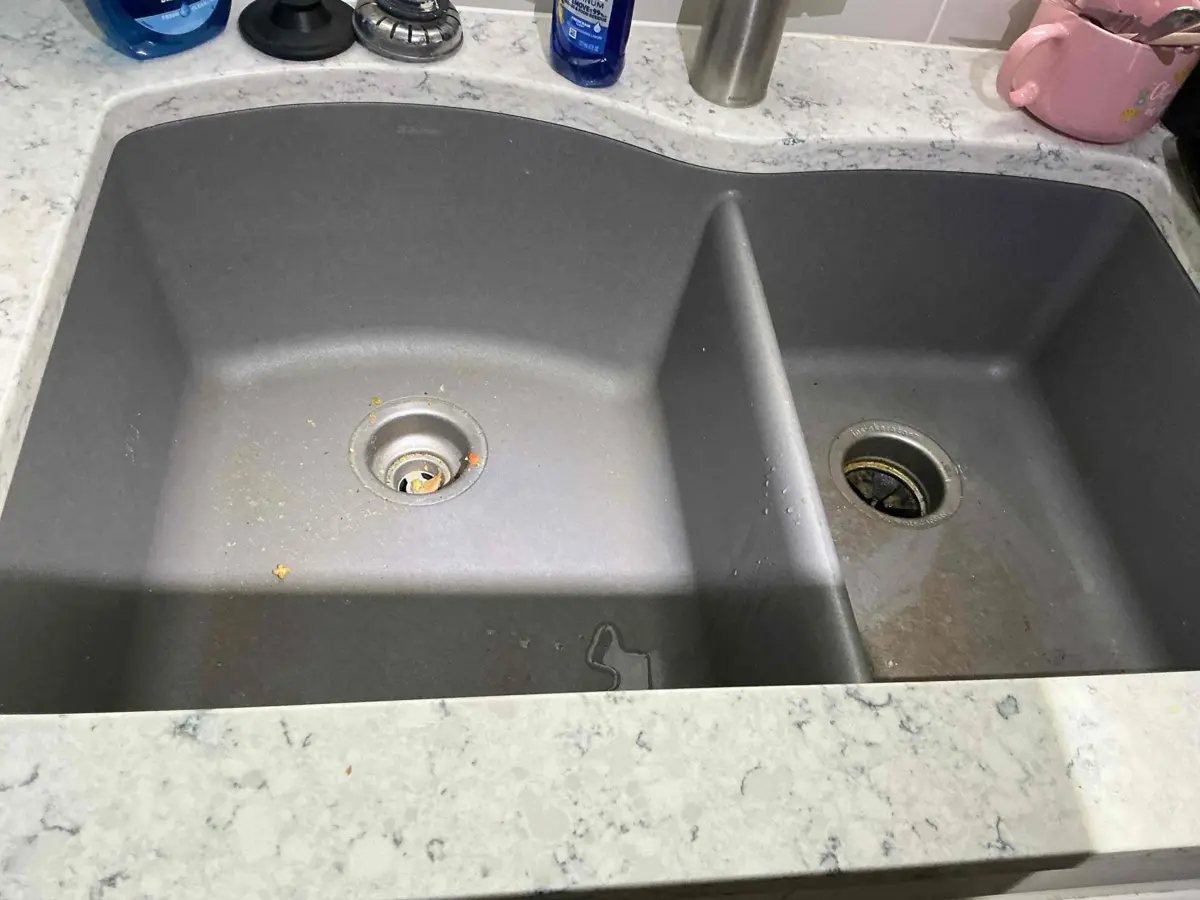 Kitchen sink backing up when the dishwasher runs, showing a shared drain clog