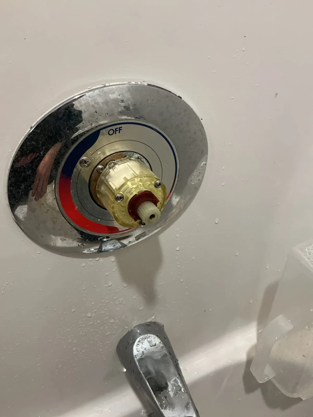 New shower cartridge seated in the valve with the hot and cold trim plate behind it