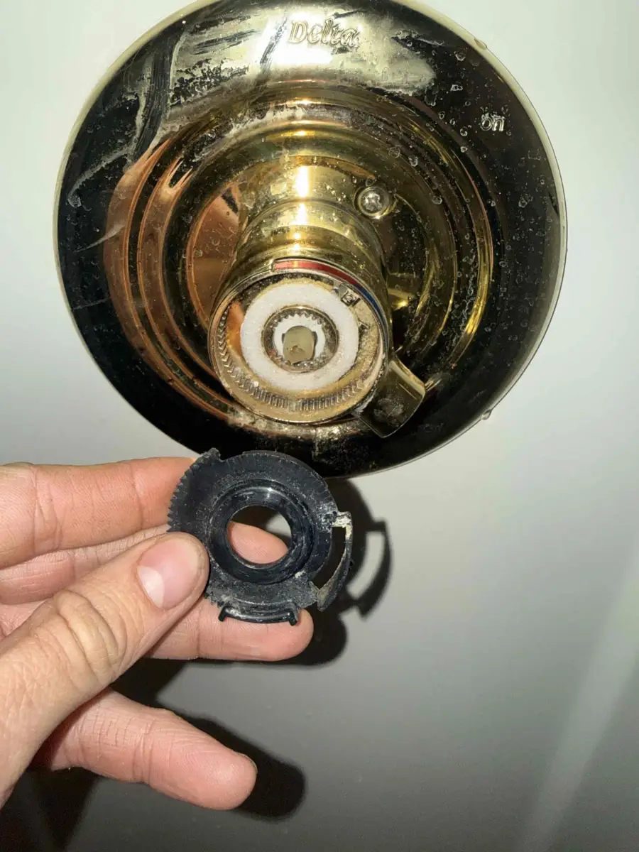 Plumber removing the retaining nut to pull a worn cartridge from a single handle shower valve