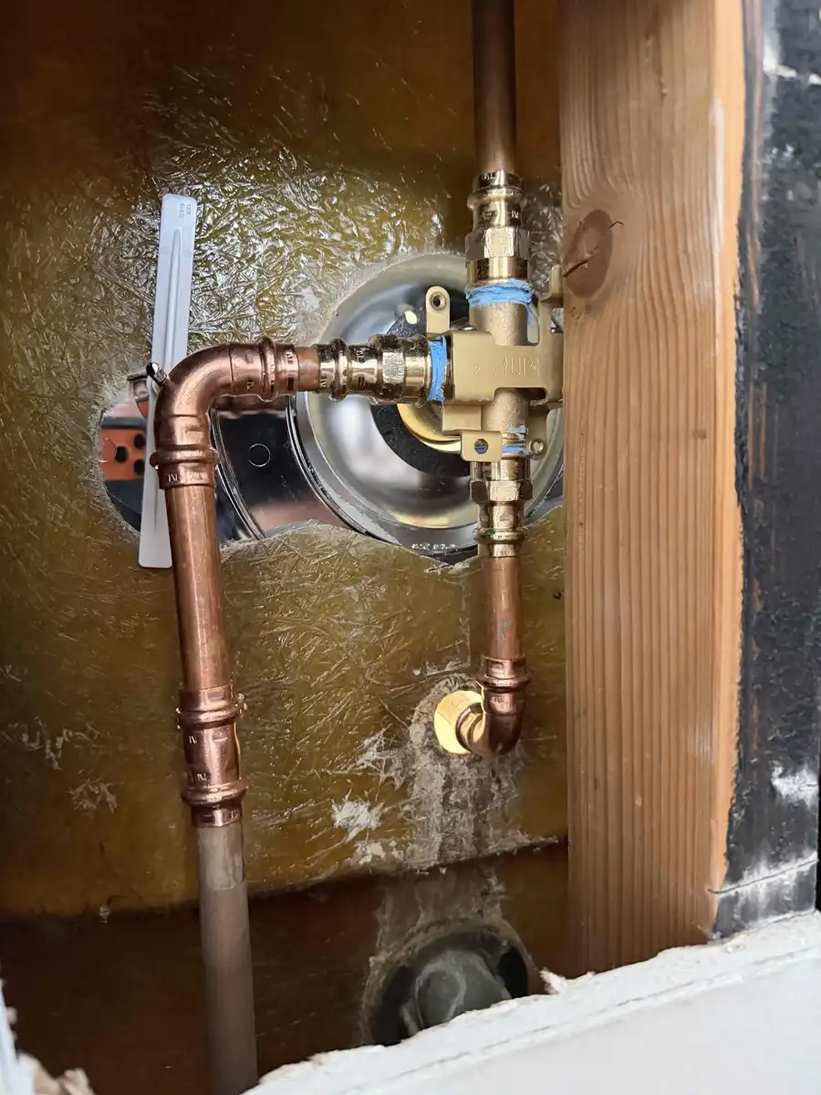 New single handle shower valve connected with copper press fittings inside an opened wall