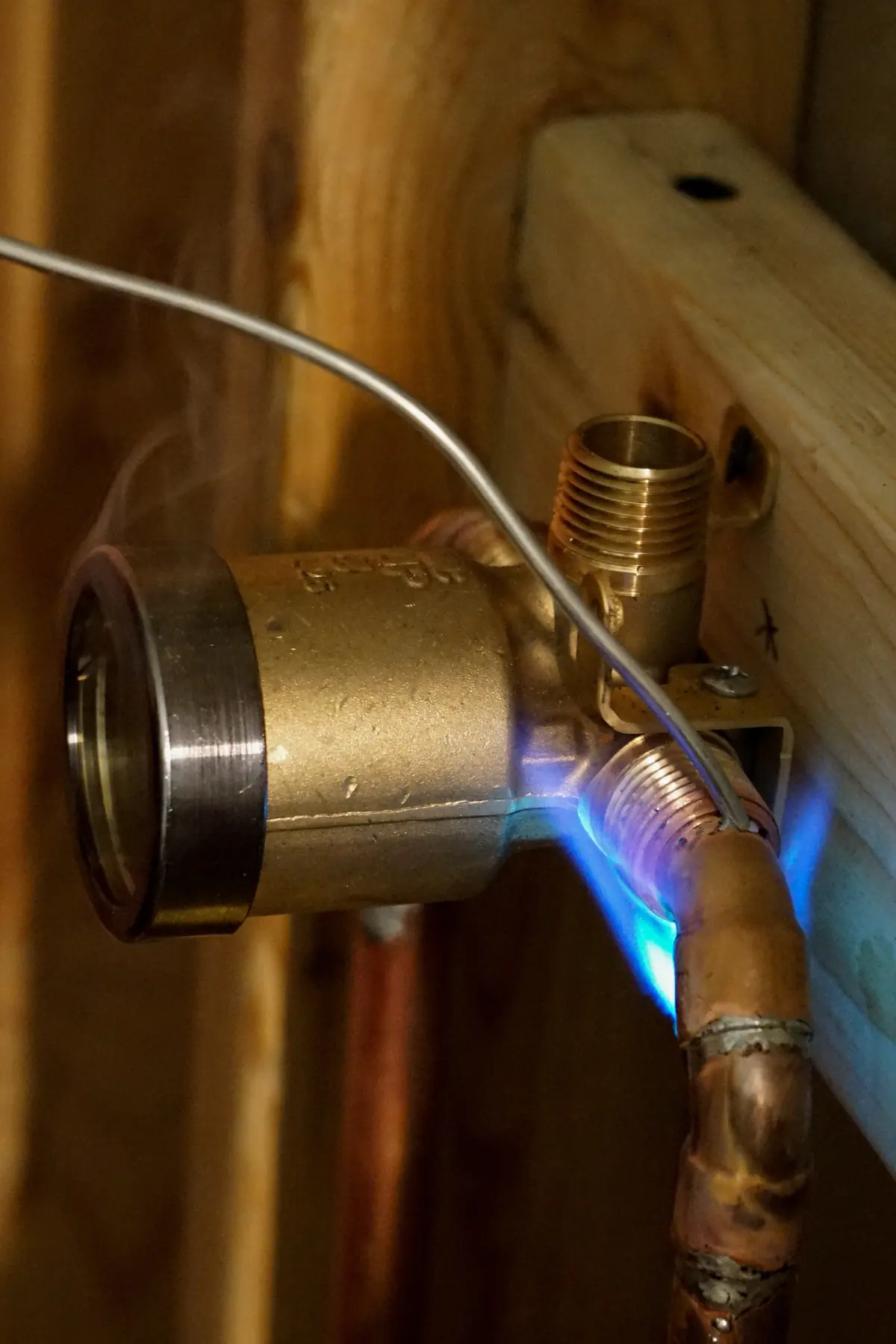 Torch soldering a brass shower valve to copper supply lines