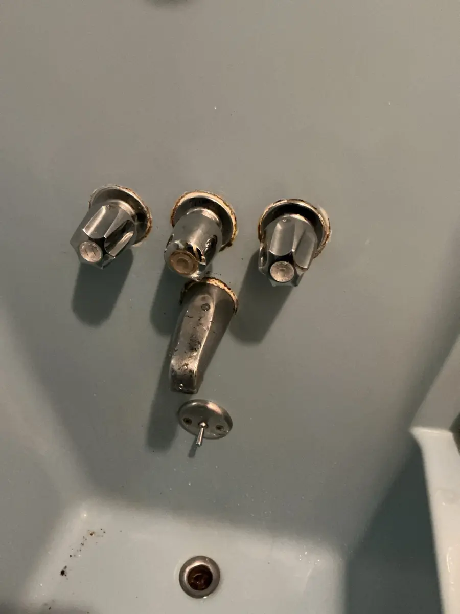 Three handle tub and shower valve with the handles removed and the brass stems exposed